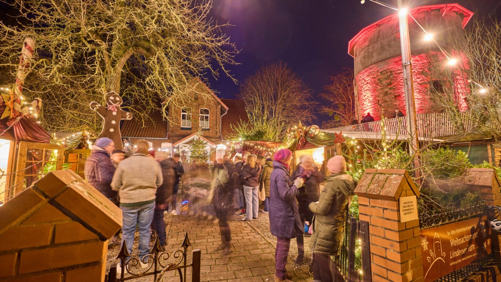 Kerstmarkt op de Lindener Berg met de rood verlichte Lindener Turm